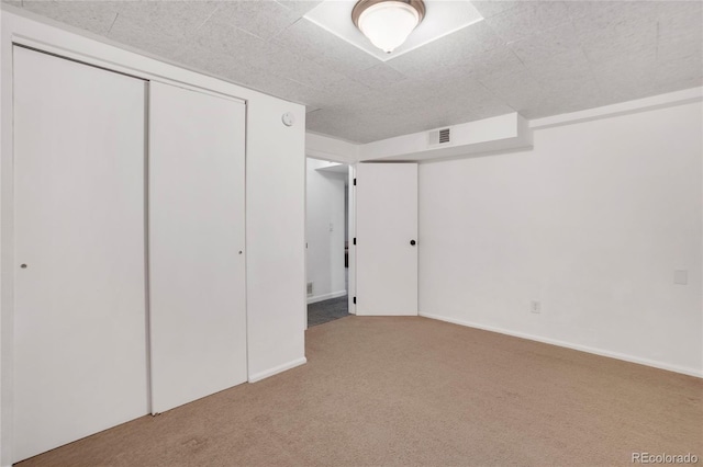 unfurnished bedroom with carpet, visible vents, and baseboards