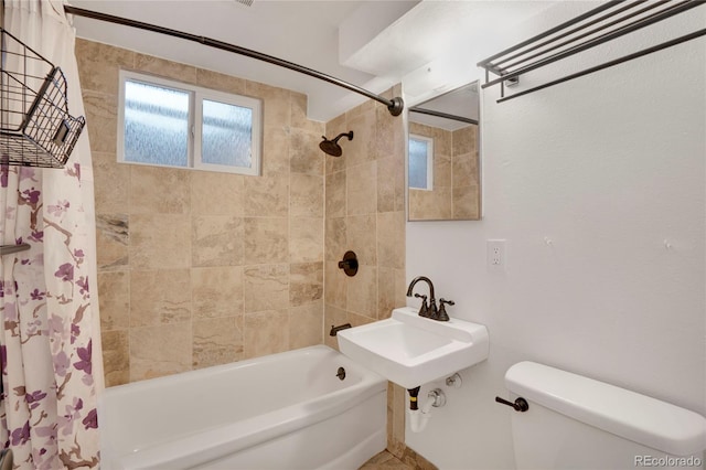 bathroom with toilet, shower / bath combo, and a sink