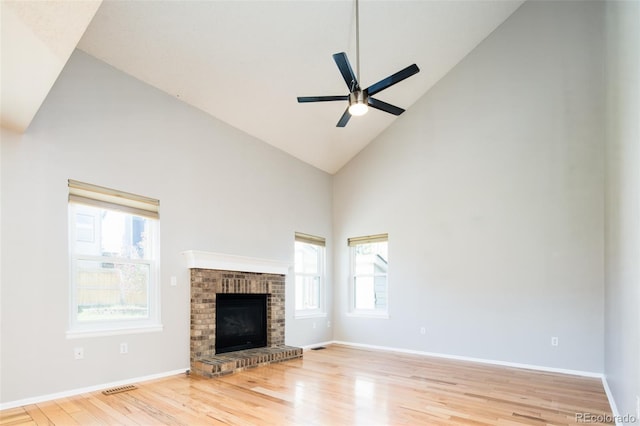 unfurnished living room featuring visible vents, wood finished floors, baseboards, ceiling fan, and high vaulted ceiling