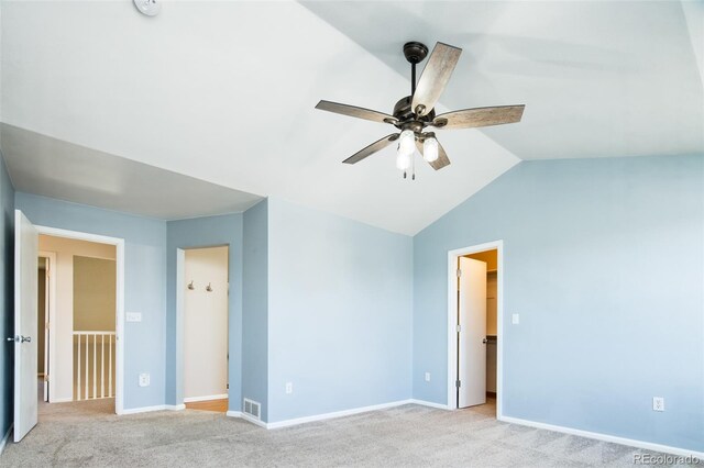 unfurnished bedroom with visible vents, baseboards, a spacious closet, carpet, and lofted ceiling