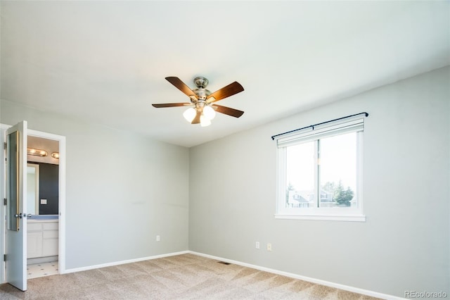 unfurnished bedroom with ensuite bathroom, baseboards, ceiling fan, and carpet