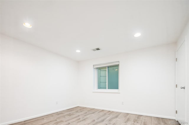 spare room featuring light wood-style floors, recessed lighting, and visible vents