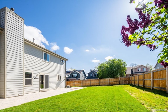 view of yard with a fenced backyard, a patio, and a residential view