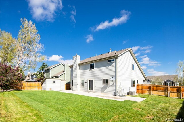 rear view of property with a storage shed, an outbuilding, cooling unit, a fenced backyard, and a patio