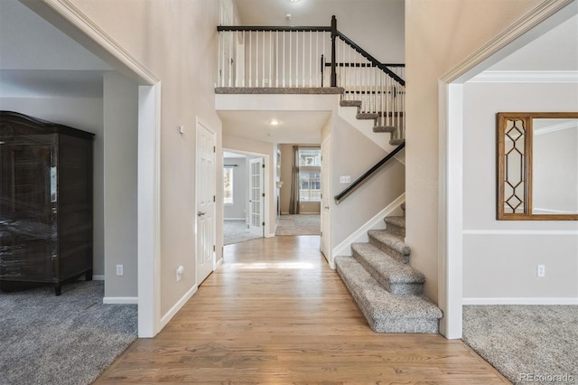 13540 Detroit St, Thornton, CO 80241 - carpeted entryway featuring stairway, wood finished floors, a high ceiling, and ornamental molding