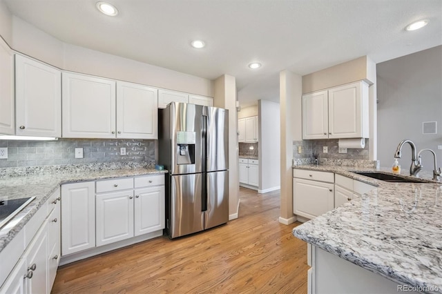 13540 Detroit St, Thornton, CO 80241 - kitchen featuring stainless steel refrigerator with ice dispenser, decorative backsplash, light wood finished floors, white cabinets, and light stone counters