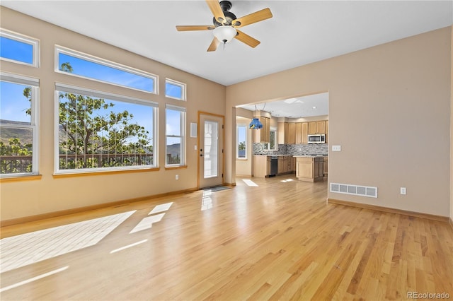 unfurnished living room with ceiling fan and light hardwood / wood-style floors