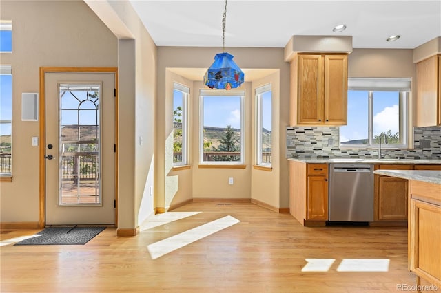 kitchen with sink, light wood-type flooring, stainless steel dishwasher, pendant lighting, and decorative backsplash