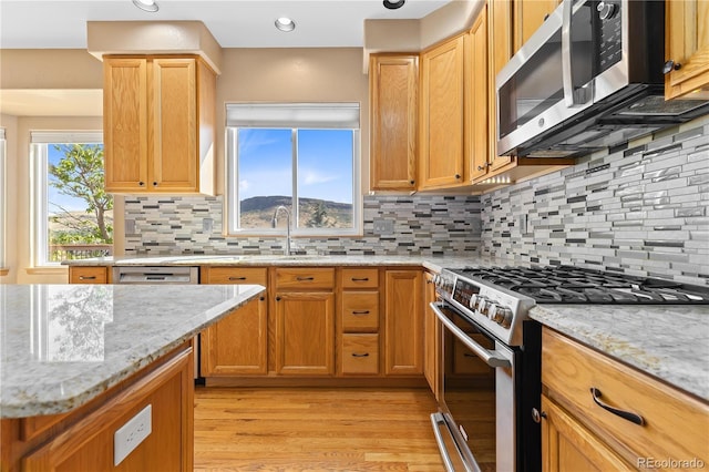 kitchen featuring stainless steel appliances, plenty of natural light, and decorative backsplash