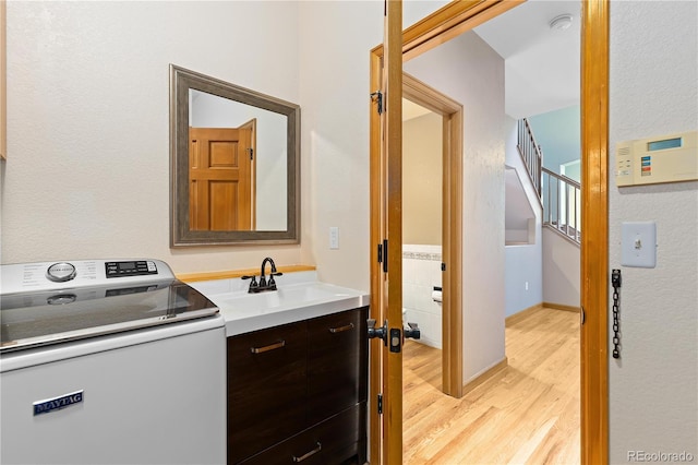 bathroom featuring washer / clothes dryer, hardwood / wood-style flooring, and sink