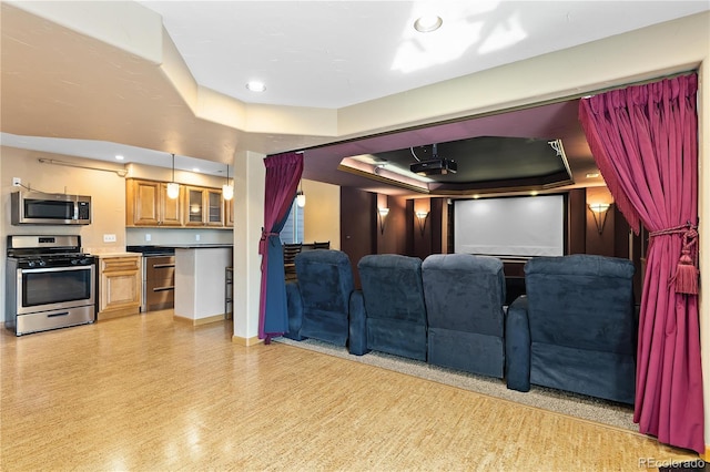 home theater with a raised ceiling and light wood-type flooring