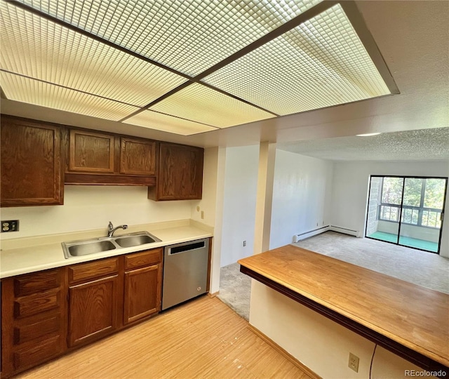 kitchen featuring dishwasher, baseboard heating, a sink, light countertops, and light colored carpet