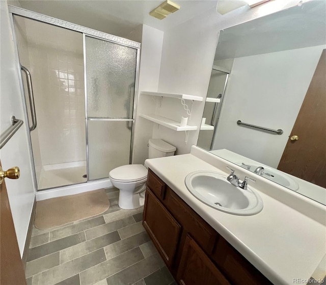 full bath with a stall shower, toilet, and vanity