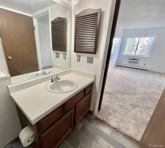 bathroom with a baseboard heating unit, vanity, a textured ceiling, and a wall mounted AC