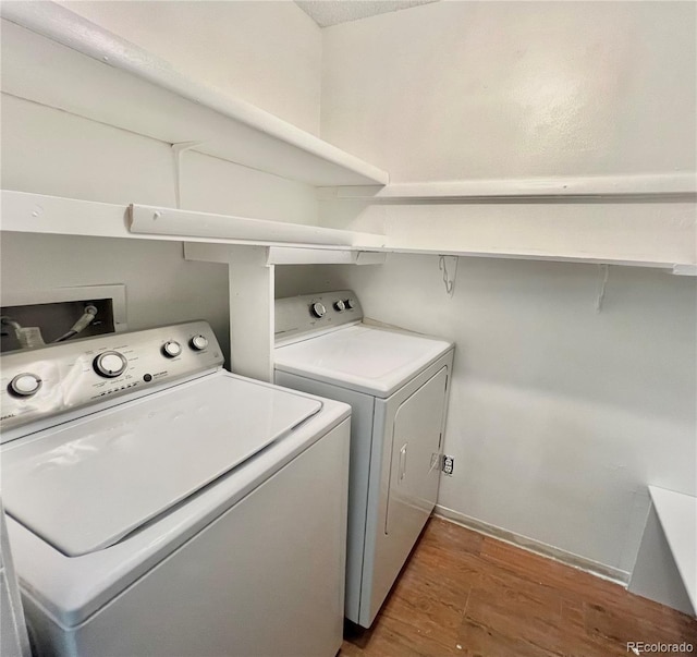 washroom featuring independent washer and dryer, wood finished floors, and baseboards
