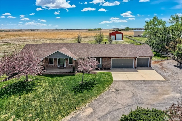 ranch-style house featuring a front lawn, covered porch, and a garage