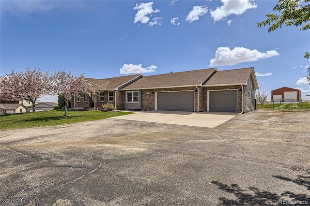 ranch-style home featuring a garage and a front yard