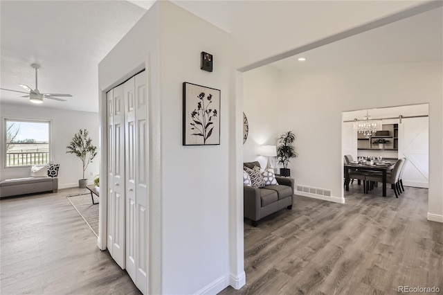 hall featuring hardwood / wood-style floors and lofted ceiling