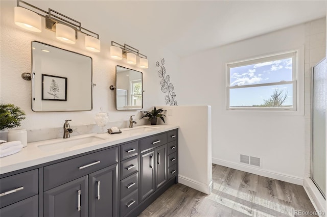 bathroom featuring a shower, hardwood / wood-style floors, and vanity