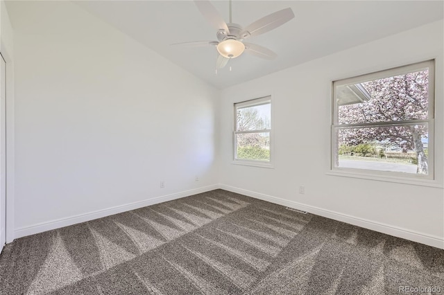 spare room featuring carpet, vaulted ceiling, and ceiling fan