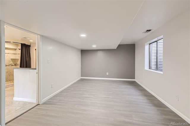 basement with light hardwood / wood-style flooring