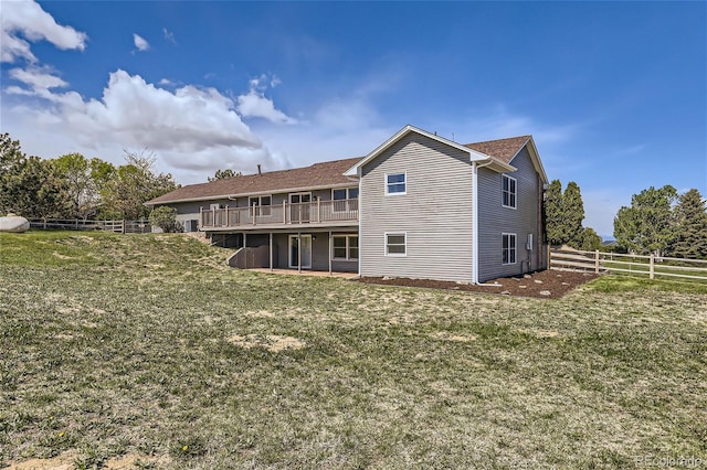 back of house featuring a yard and a wooden deck