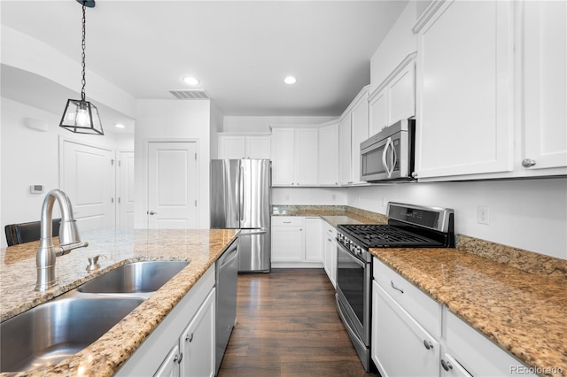 kitchen featuring sink, white cabinetry, decorative light fixtures, stainless steel appliances, and light stone countertops