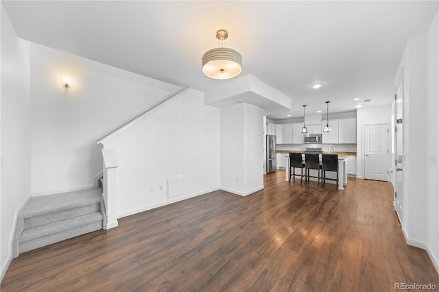 unfurnished living room with sink and dark hardwood / wood-style floors