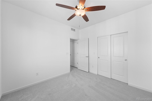 unfurnished bedroom with ceiling fan, a closet, and light colored carpet