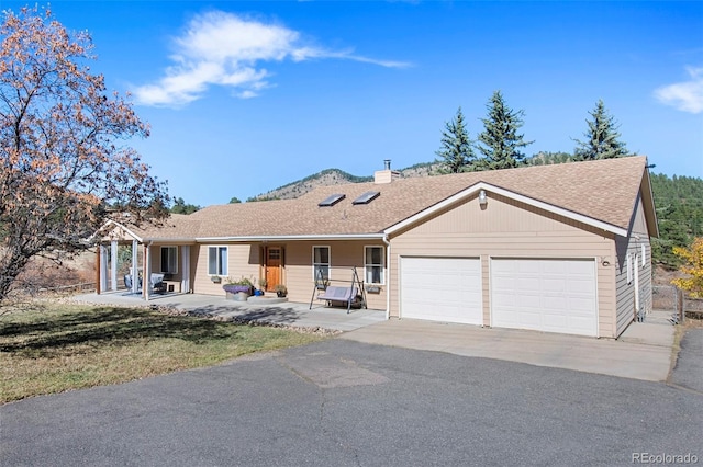 ranch-style house with covered porch, a garage, and a front lawn