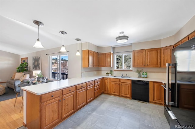 kitchen with kitchen peninsula, stainless steel fridge, sink, pendant lighting, and dishwasher