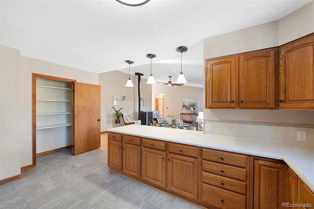 kitchen featuring kitchen peninsula, ceiling fan, and hanging light fixtures