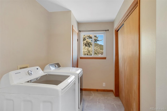 washroom with laundry area, baseboards, and washer and dryer