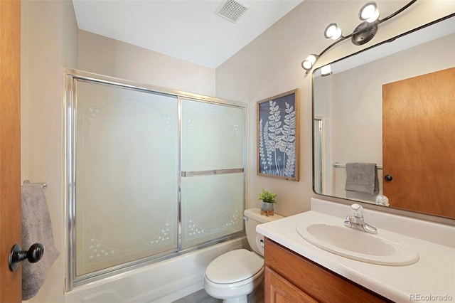 bathroom featuring toilet, visible vents, bath / shower combo with glass door, and vanity