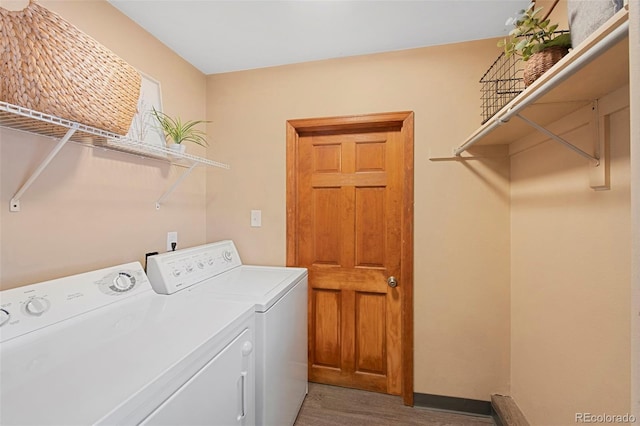 laundry area with light wood-type flooring, laundry area, baseboards, and separate washer and dryer