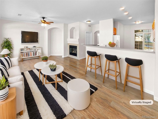 living room with ceiling fan and light hardwood / wood-style flooring