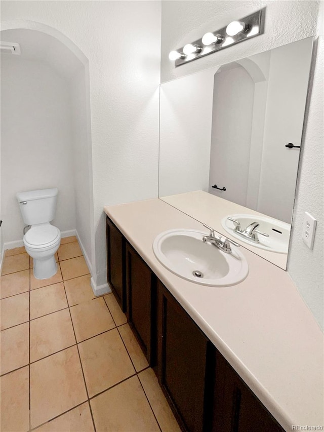 bathroom featuring toilet, vanity, and tile patterned floors