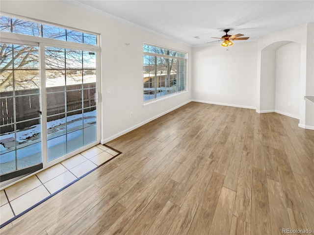 spare room featuring ceiling fan, a wealth of natural light, crown molding, and light hardwood / wood-style floors