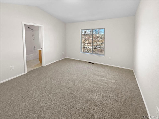 carpeted empty room with lofted ceiling