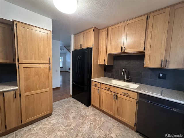 kitchen with a textured ceiling, a sink, light countertops, black appliances, and tasteful backsplash