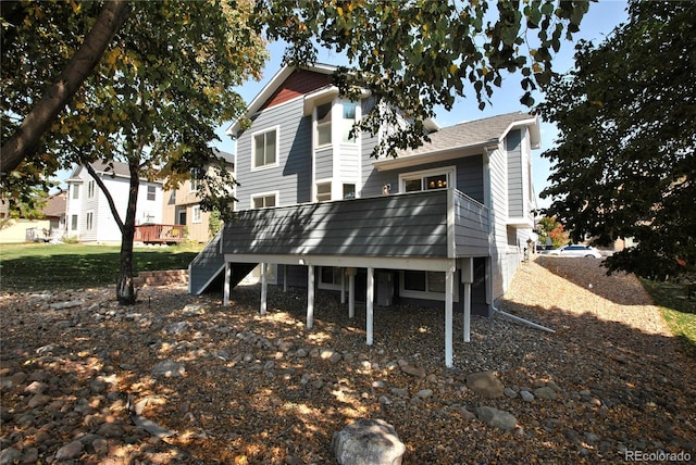 rear view of house featuring a deck and stairway