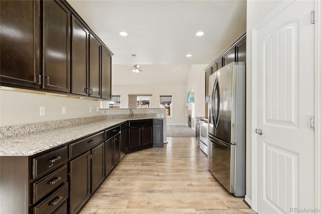 kitchen with stainless steel refrigerator, light stone counters, kitchen peninsula, dark brown cabinets, and light hardwood / wood-style flooring