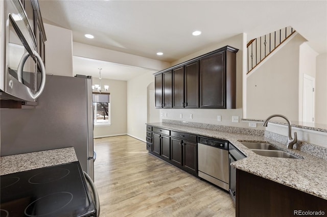 kitchen featuring sink, appliances with stainless steel finishes, hanging light fixtures, dark brown cabinets, and light stone countertops