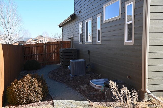 view of side of home featuring fence and central air condition unit