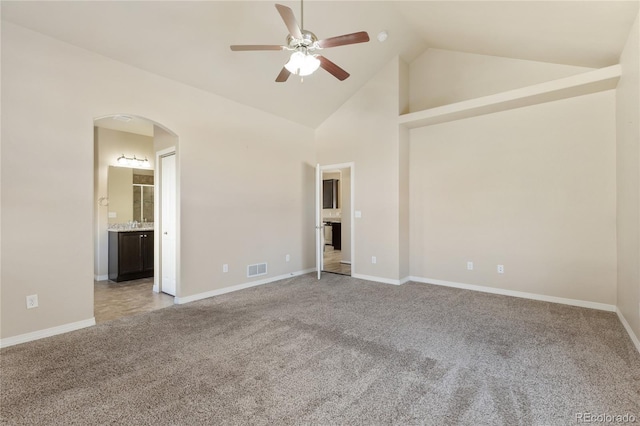 spare room with ceiling fan, arched walkways, light carpet, and baseboards