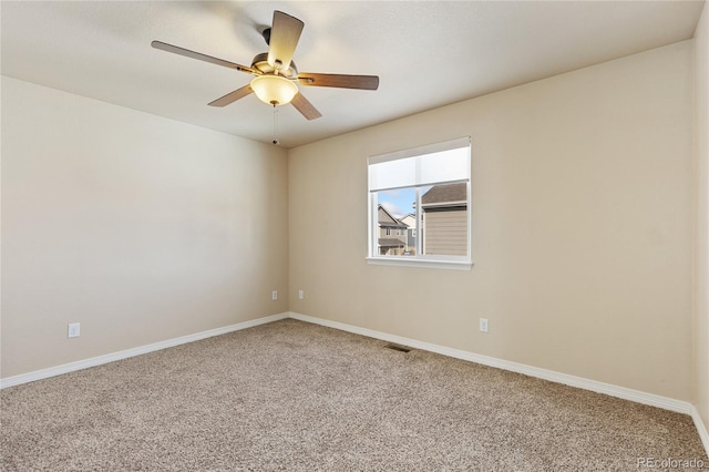 carpeted empty room with baseboards, a ceiling fan, and visible vents