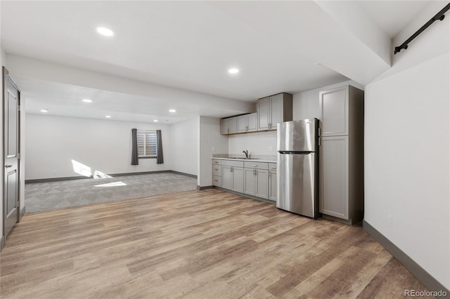 kitchen with recessed lighting, a sink, freestanding refrigerator, and gray cabinets