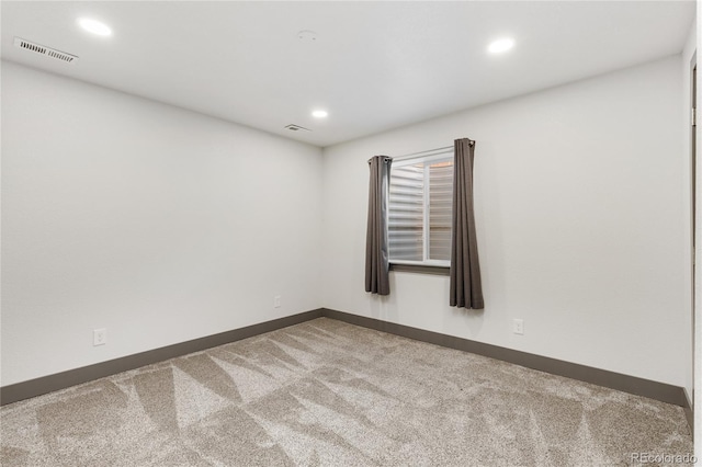 spare room featuring carpet flooring, baseboards, visible vents, and recessed lighting
