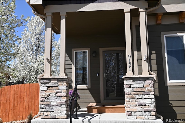 property entrance featuring a porch and fence
