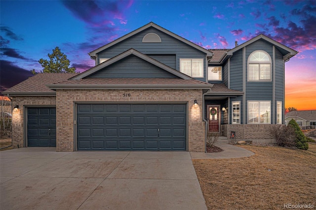 traditional-style home with brick siding, driveway, an attached garage, and roof with shingles